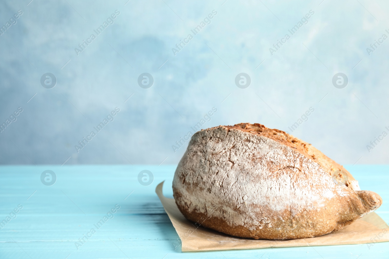 Photo of Fresh bread on table against color background. Space for text