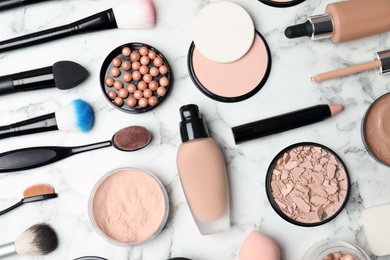 Photo of Flat lay composition with skin foundation, powder and beauty accessories on marble background
