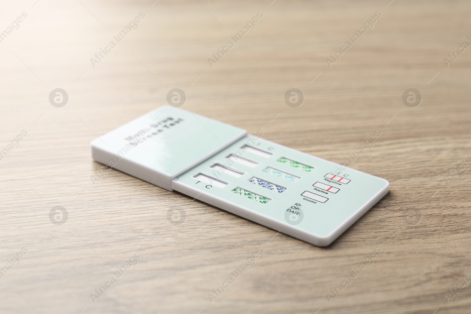 Photo of Multi-drug screen test on light wooden table, closeup