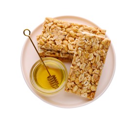 Photo of Plate with tasty peanut bars (kozinaki) and honey isolated on white, top view