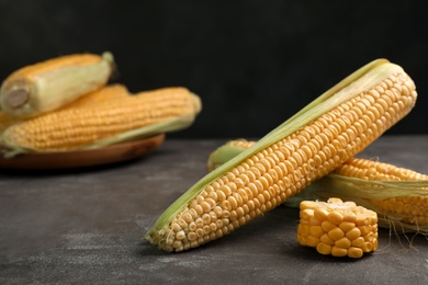 Photo of Tasty ripe corn cobs on grey table