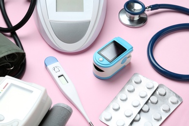 Photo of Digital pressure meter and medical objects on color background