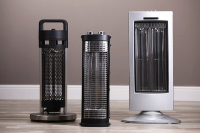Photo of Different modern infrared heaters on floor indoors