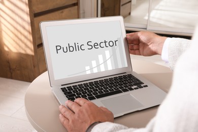 Image of Public Sector. Man working with modern laptop at table, closeup 