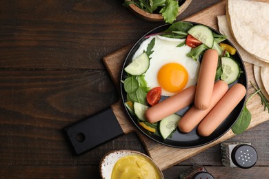 Photo of Delicious breakfast with boiled sausages and fried egg served on wooden table, flat lay. Space for text