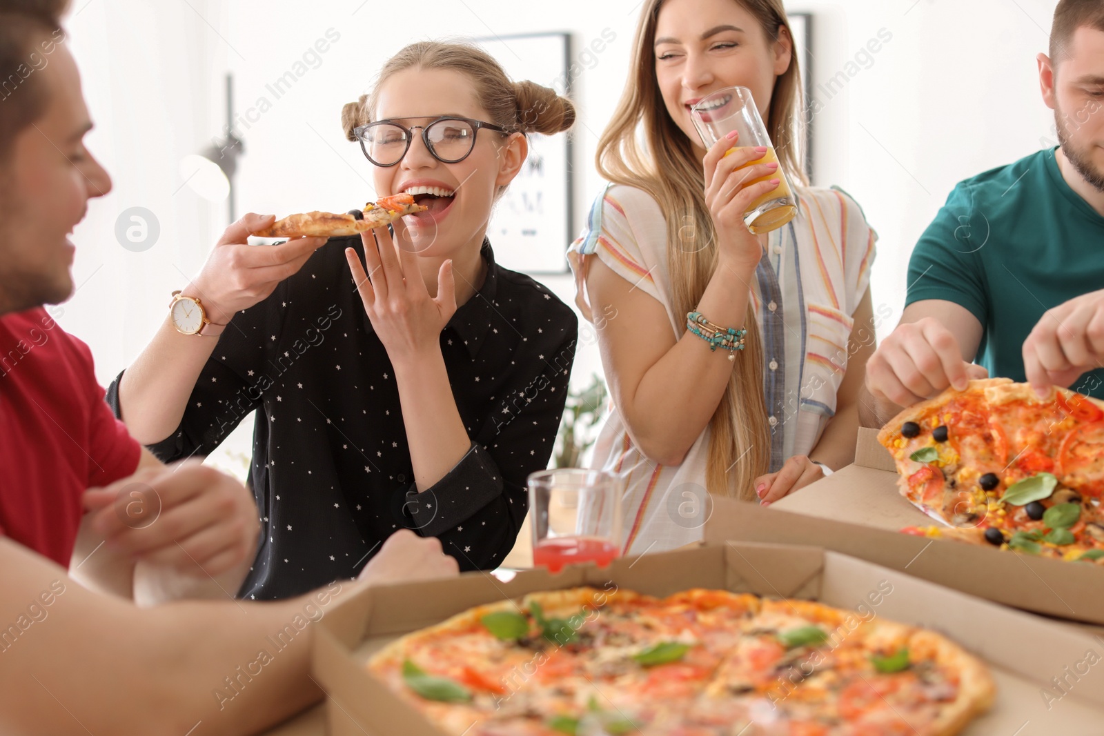 Photo of Young people having fun party with delicious pizza indoors