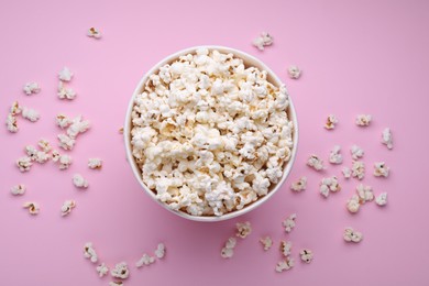 Bucket of tasty popcorn on pink background, flat lay