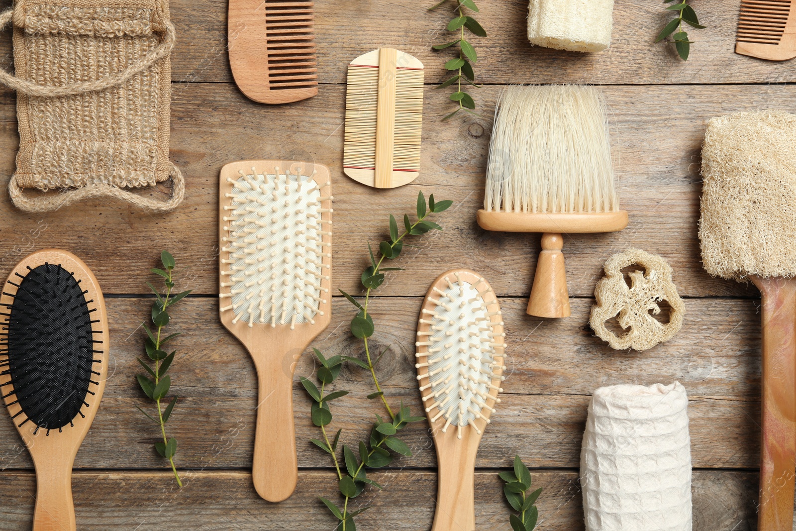 Photo of Flat lay composition with hair brushes and combs on wooden background