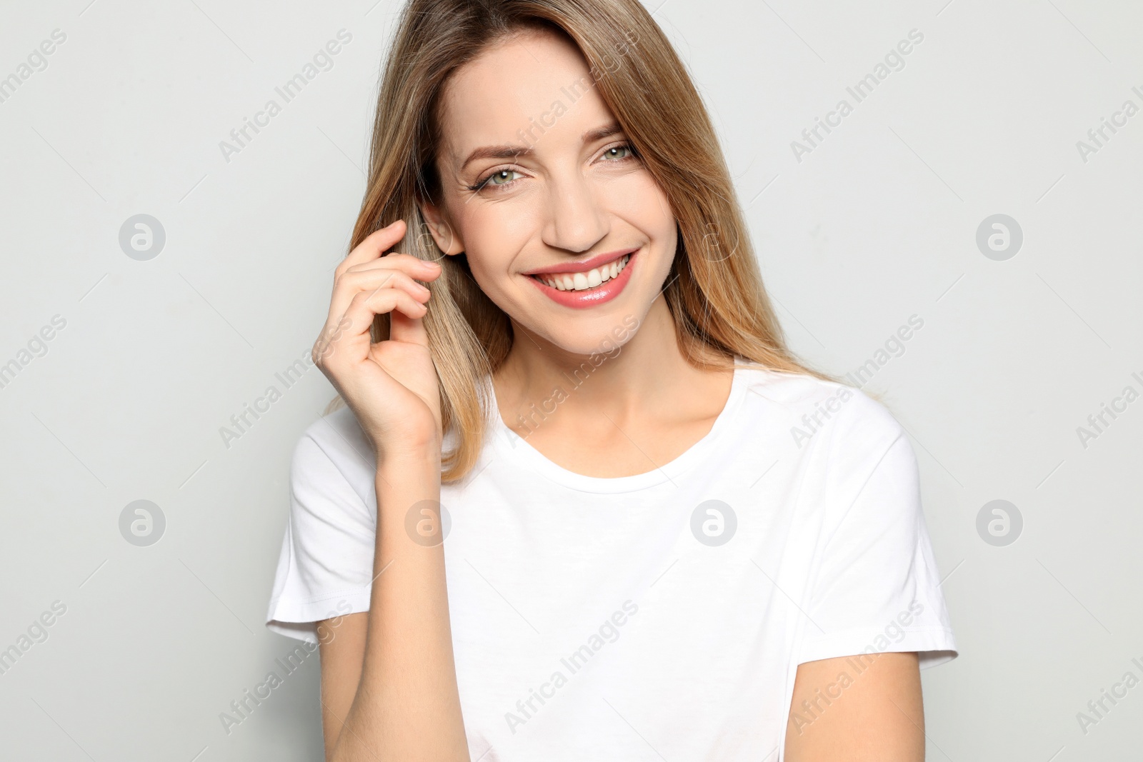 Photo of Portrait of young woman with beautiful face on grey background