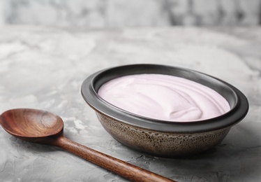 Bowl with tasty yogurt on table