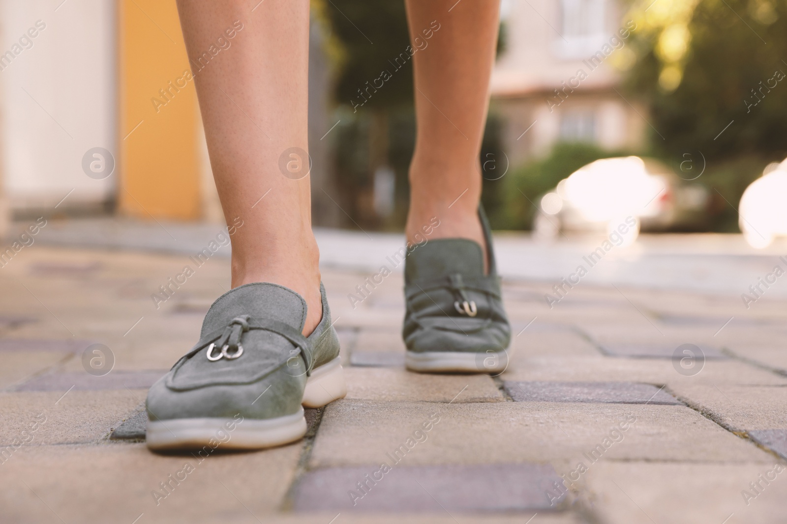 Photo of Woman in stylish loafers walking on city street, closeup