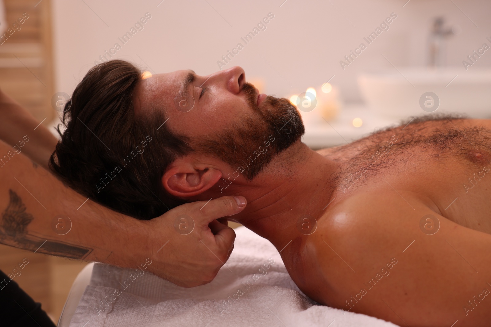 Photo of Man receiving professional neck massage in spa salon