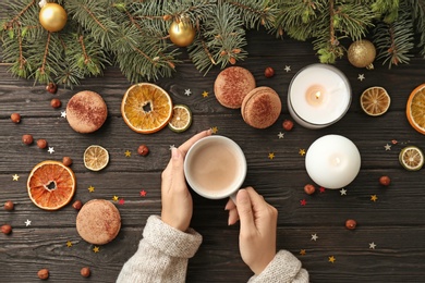 Woman with delicious hot cocoa drink at table, top view