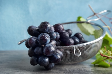 Photo of Fresh ripe juicy grapes in colander on table