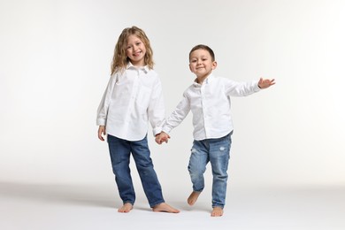 Photo of Cute little children on white background. Happy family