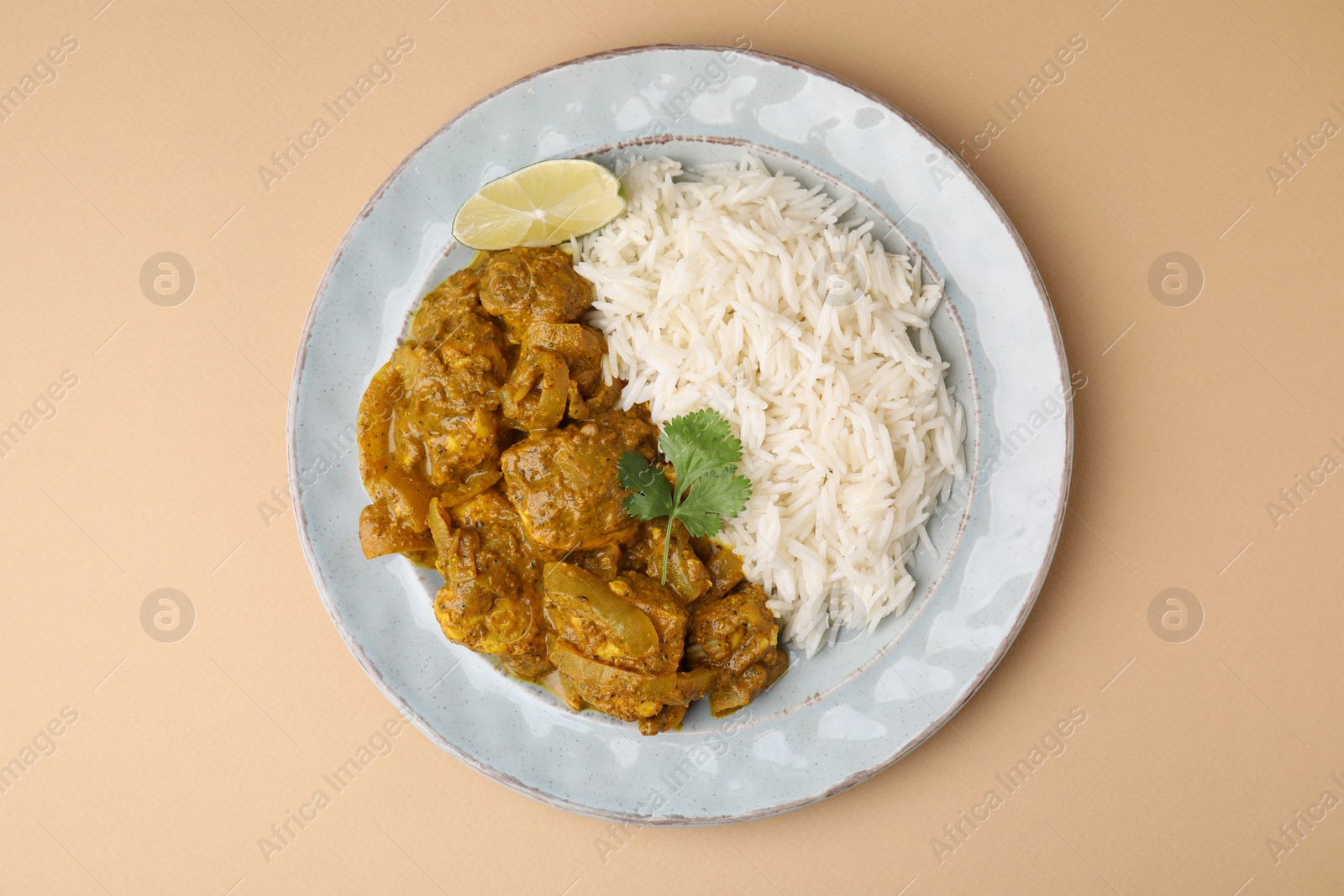 Photo of Delicious chicken curry with rice on beige background, top view