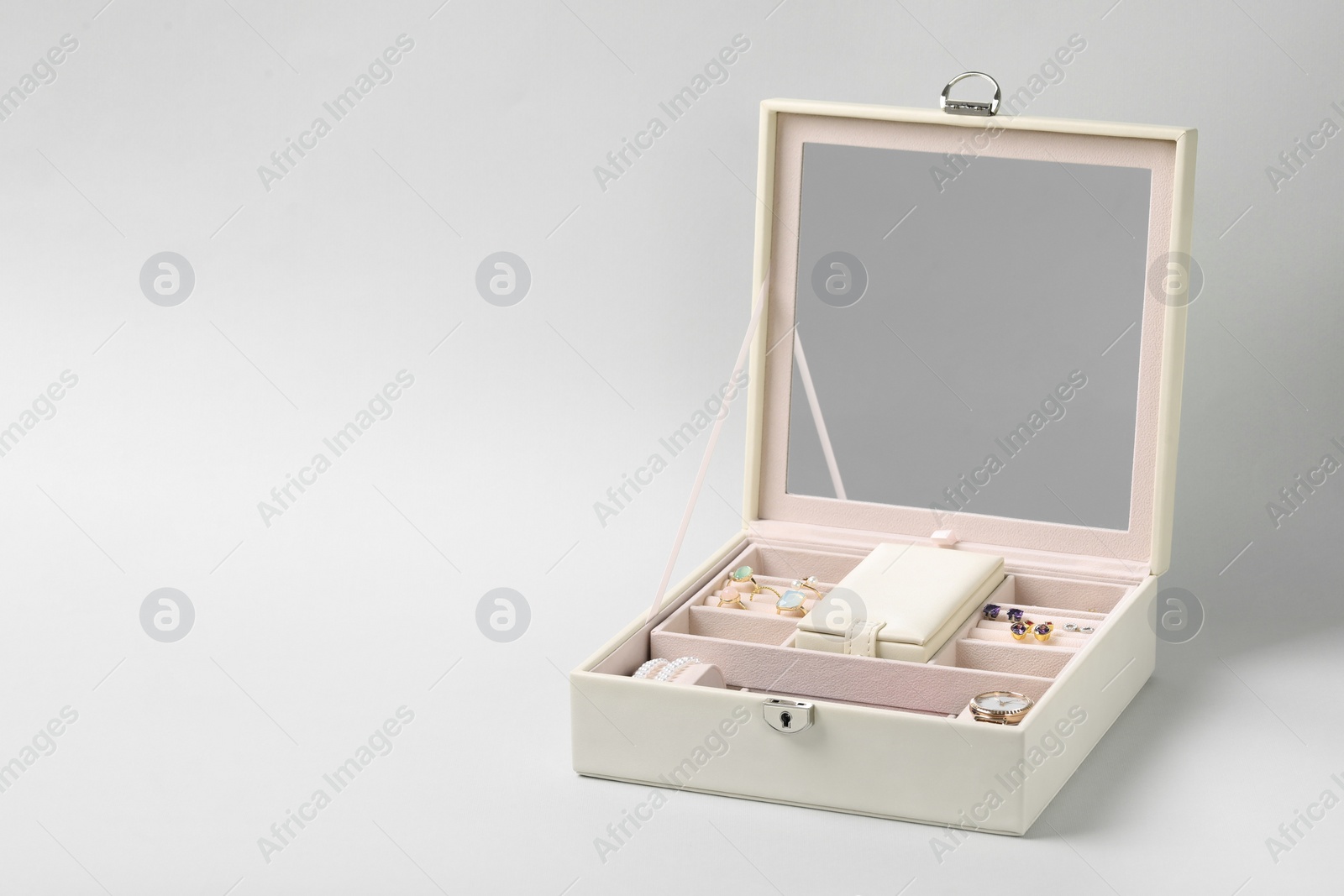 Photo of Jewelry box with many different accessories on light background, space for text