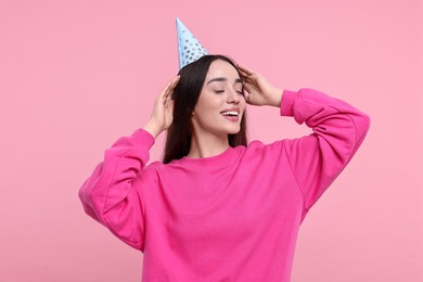 Photo of Happy woman in party hat on pink background
