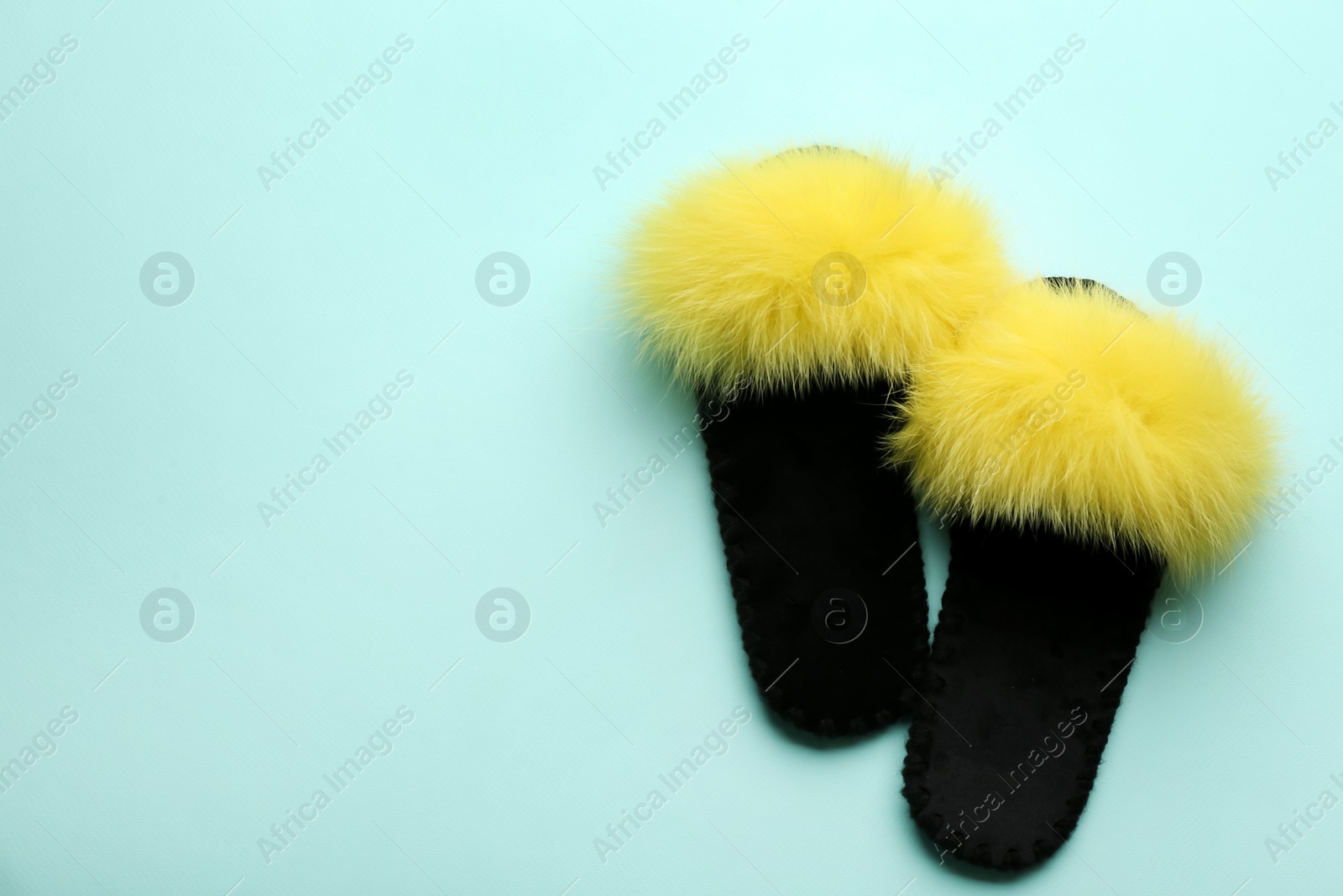 Photo of Pair of soft slippers on light blue background, flat lay. Space for text