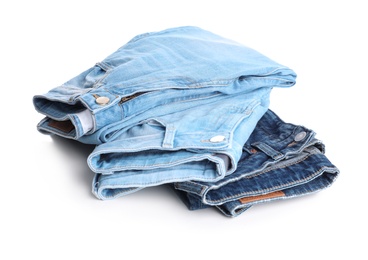 Photo of Stack of stylish jeans on white background