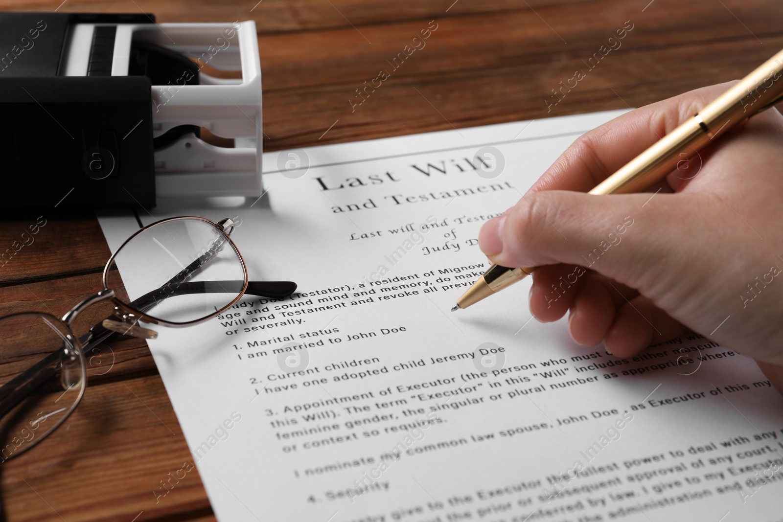 Photo of Woman signing Last Will and Testament at wooden table, closeup