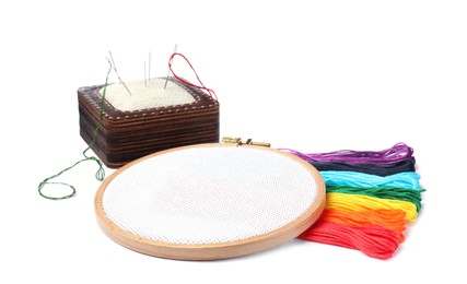 Photo of Colorful threads and different embroidery accessories on white background