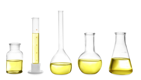 Different laboratory glassware with yellow liquid isolated on white