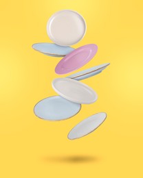 Image of Many different plates falling on yellow background