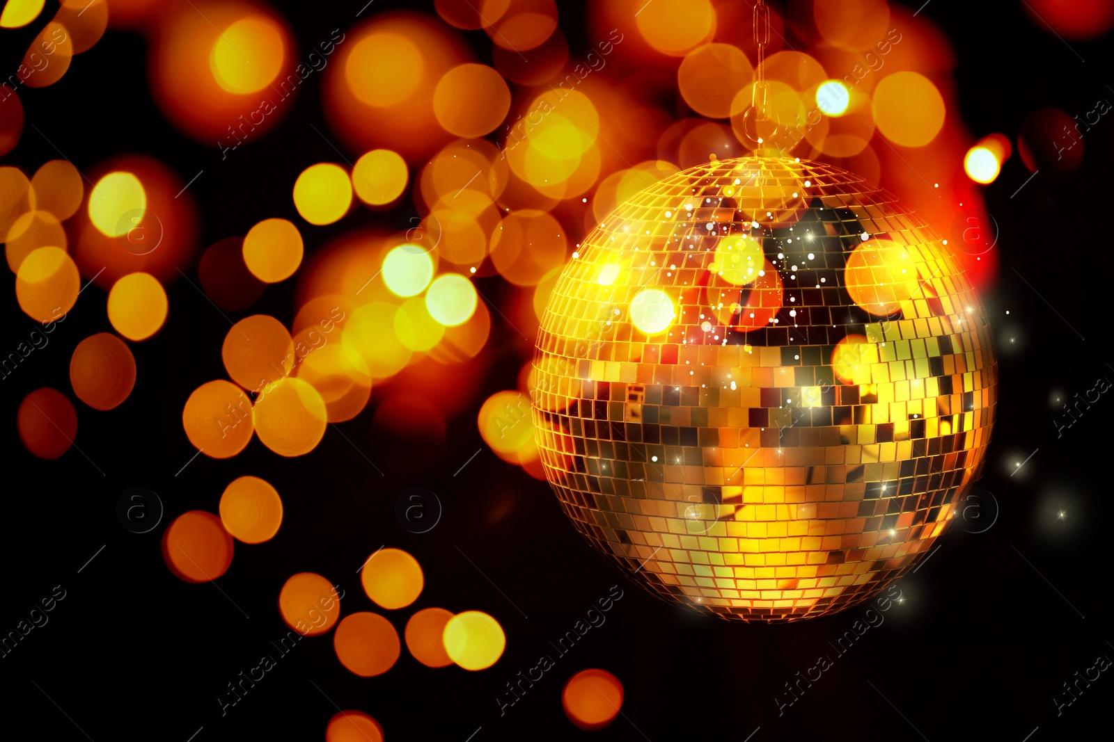 Image of Shiny disco ball on black background with blurred lights, bokeh effect