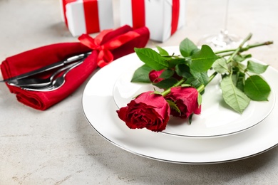 Photo of Beautiful table setting for Valentine's Day dinner with roses on white background, closeup