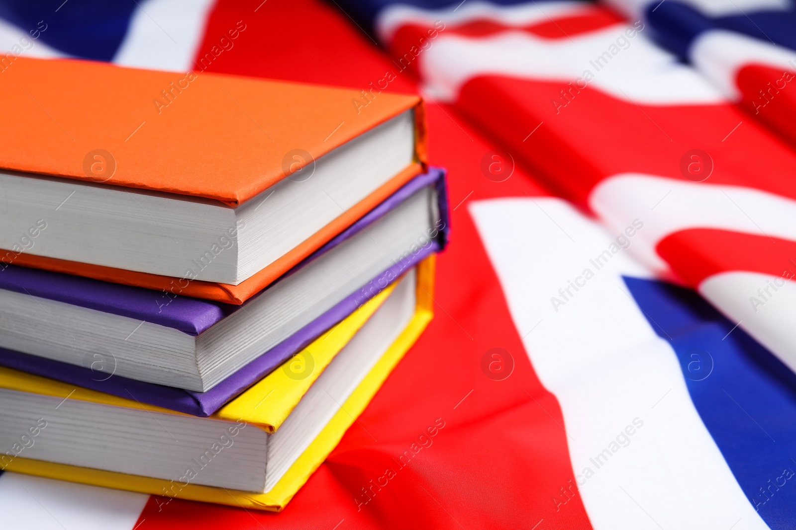 Photo of Learning foreign language. Different books on flag of United Kingdom, space for text