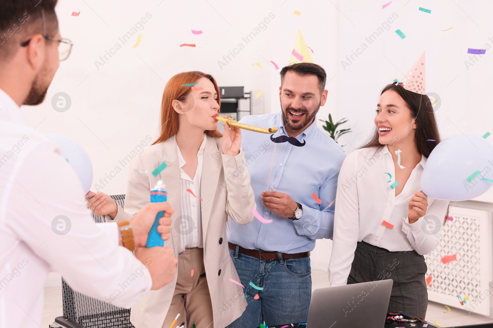 Photo of Coworkers having fun during office party indoors