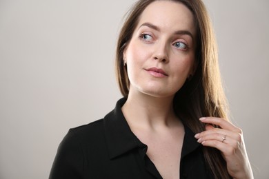 Portrait of beautiful young woman on beige background