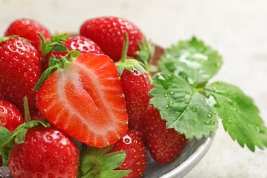 Photo of Bowl with ripe strawberries on light background, closeup