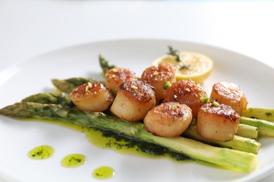 Delicious fried scallops with asparagus, lemon and thyme on white background, closeup