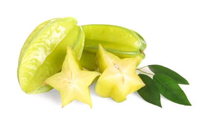 Cut and whole carambolas with green leaves on white background