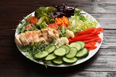 Photo of Balanced diet and healthy foods. Plate with different delicious products on wooden table