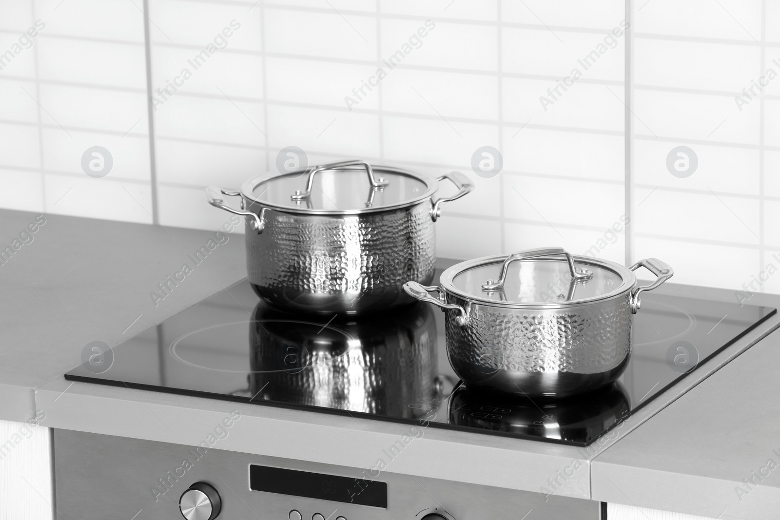 Photo of Clean pans on modern stove in kitchen