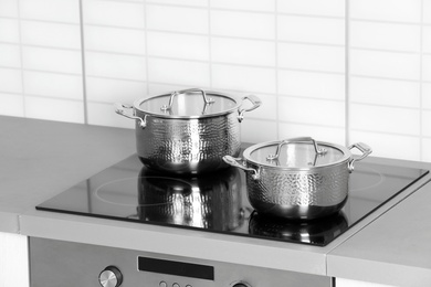 Photo of Clean pans on modern stove in kitchen