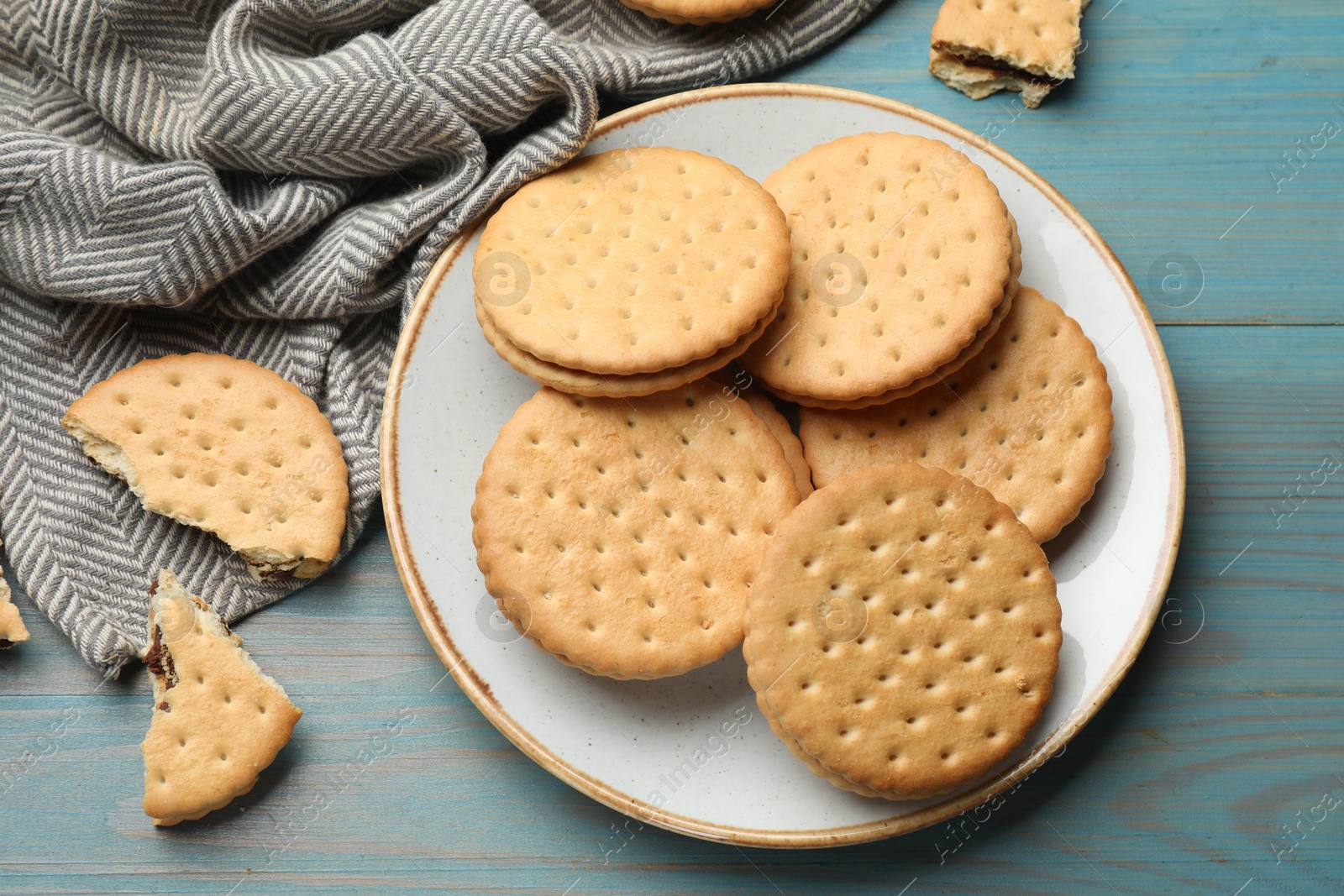 Photo of Tasty sandwich cookies on light blue wooden table, top view