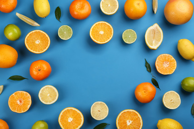 Flat lay composition with tangerines and different citrus fruits on blue background. Space for text