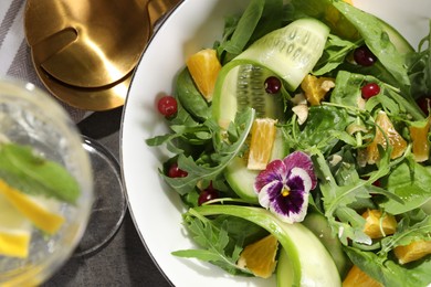 Photo of Delicious salad with cucumber and orange slices on gray table, flat lay