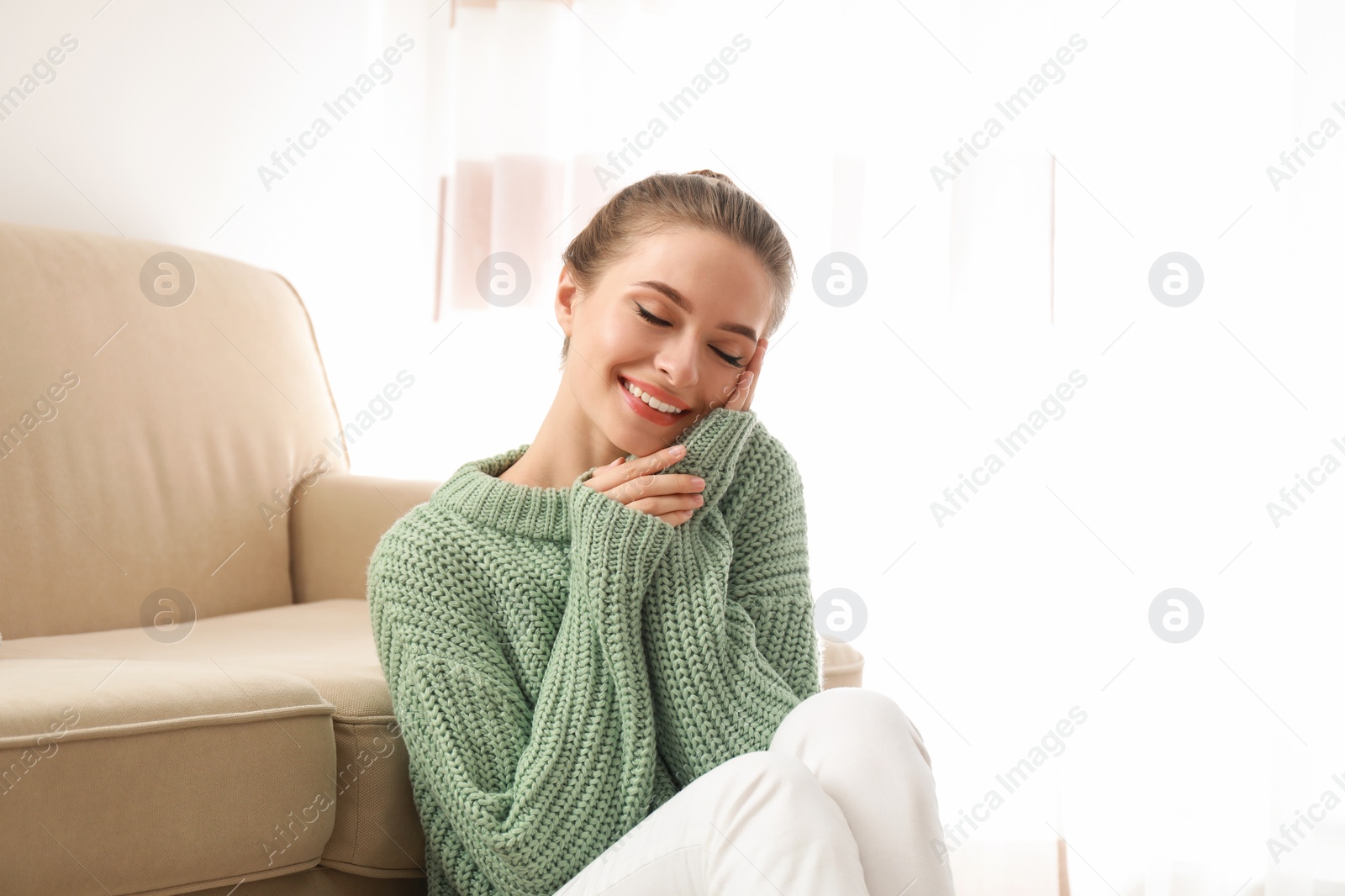 Image of Beautiful woman wearing warm sweater at home