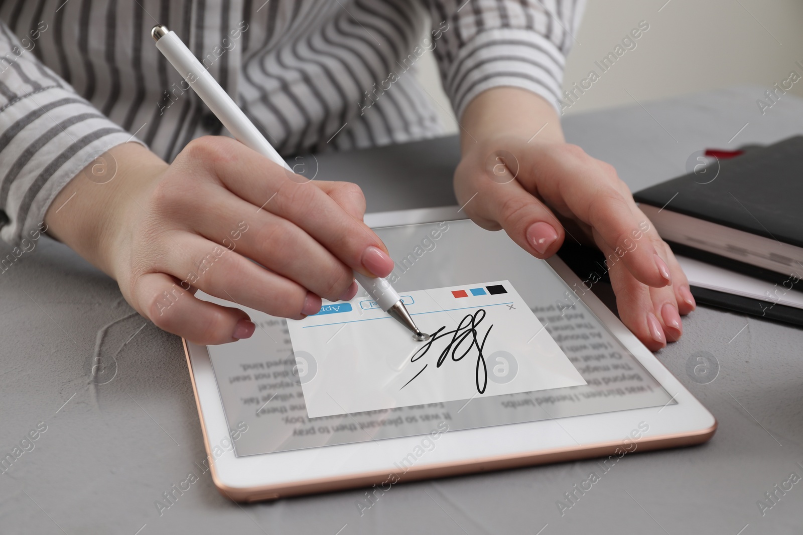 Image of Electronic signature. Woman using stylus and tablet at table, closeup