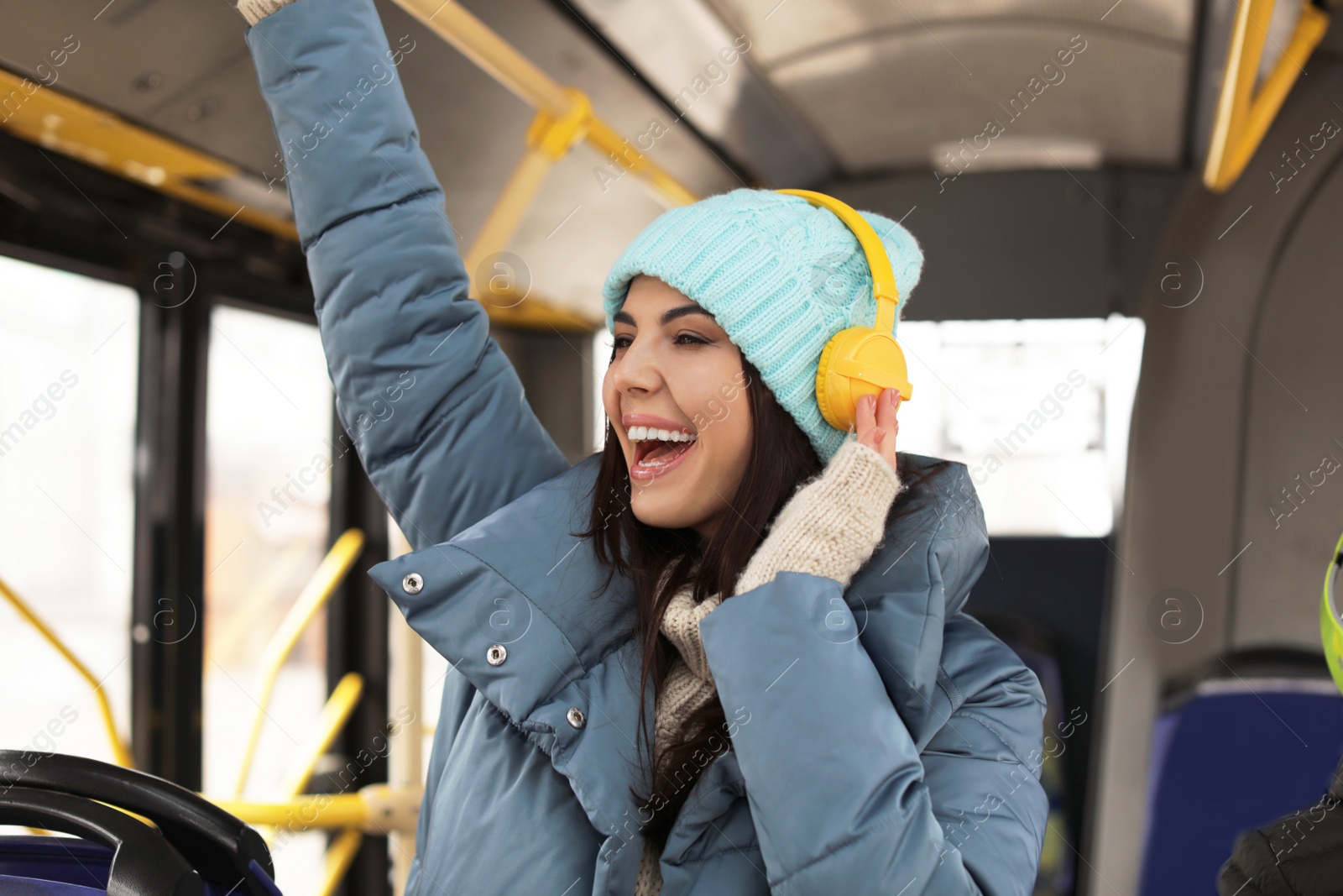 Photo of Young woman listening to music with headphones in public transport