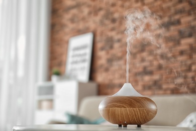 Photo of Aroma oil diffuser on table at home. Air freshener