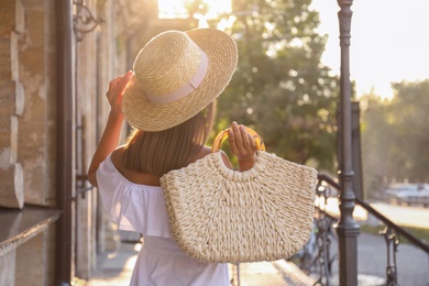 Photo of Young woman with stylish straw bag outdoors