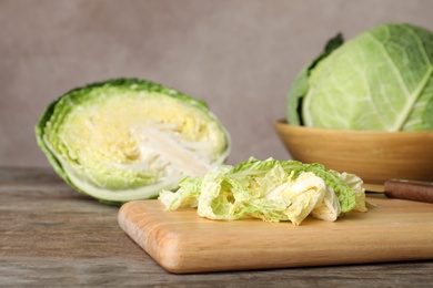 Photo of Cutting board with shredded savoy cabbage on wooden table