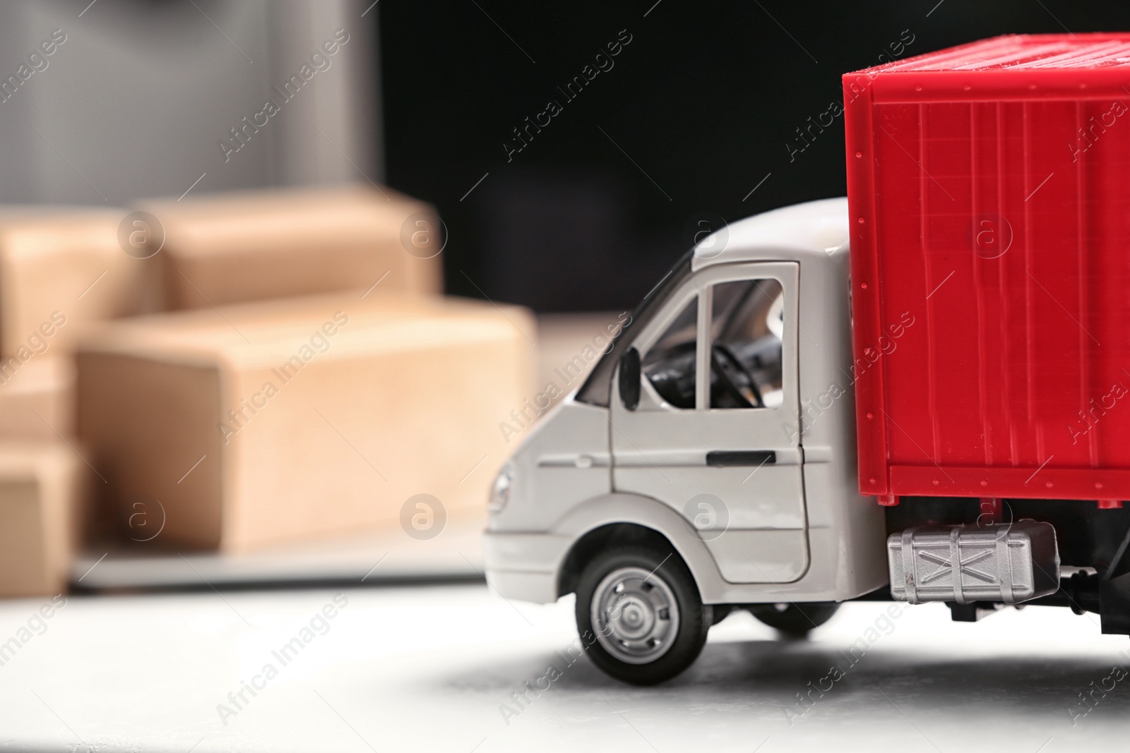 Photo of Toy truck near laptop on table. Logistics and wholesale concept