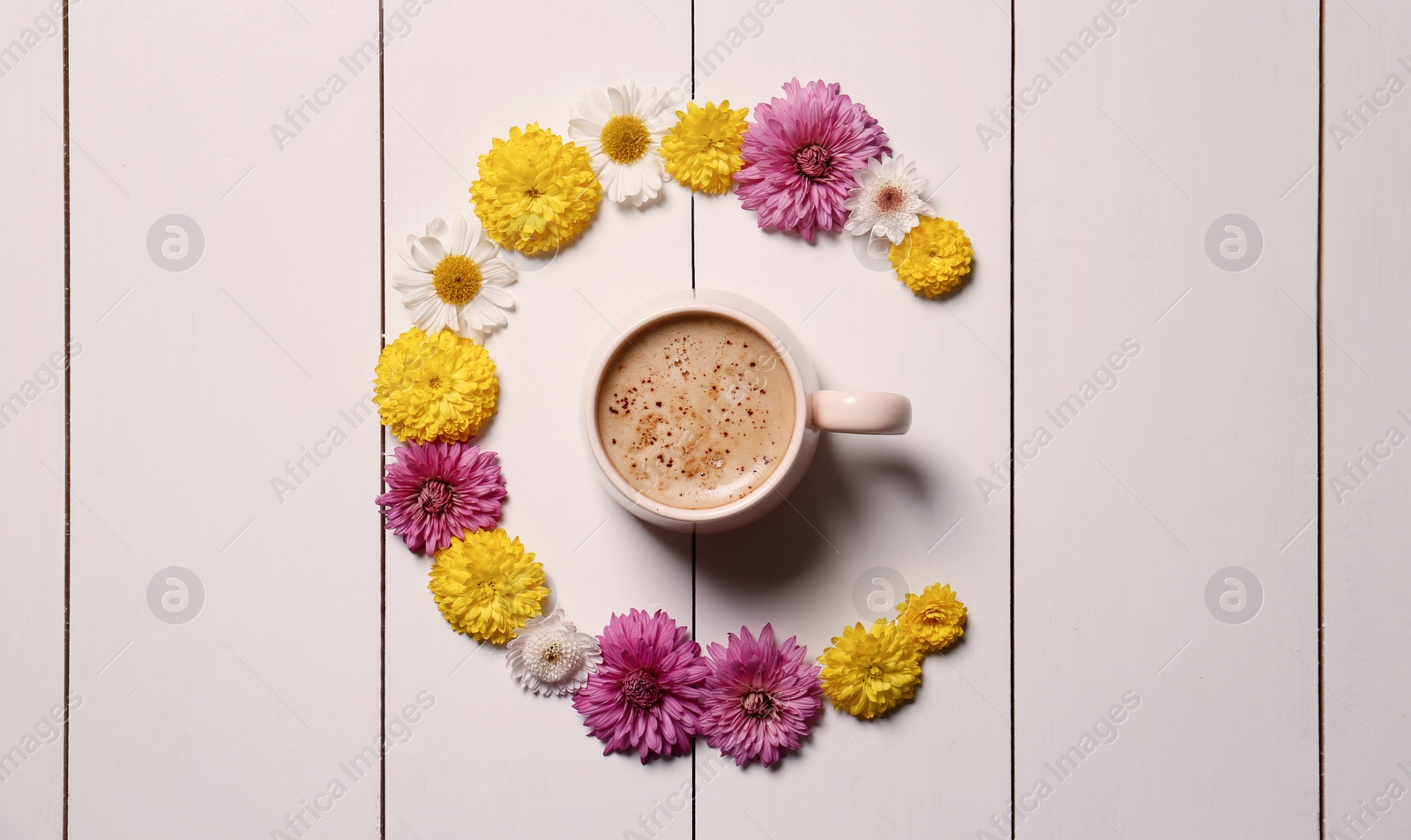 Photo of Beautiful floral composition with cup of hot coffee on white wooden background, flat lay